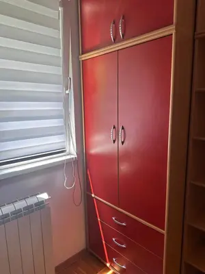 a red cabinet in a room with a window at Cozy two bedroom in Belgrade in Belgrade