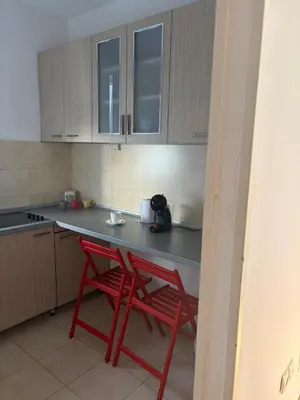 a kitchen with two red chairs and a counter at Cozy two bedroom in Belgrade in Belgrade