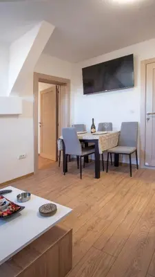 a kitchen and living room with a table and chairs at Bingo's apartman in Belgrade