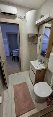 a bathroom with a toilet and a sink and a mirror at Bingo's apartman in Belgrade