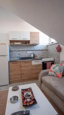 a living room with a couch and a kitchen at Bingo's apartman in Belgrade