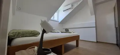 a small room with a bed with a lamp on it at Bingo's apartman in Belgrade