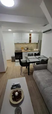 a living room with a couch and a plate of food on a table at Vanja's Apartman in Belgrade