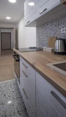a kitchen with white cabinets and a wooden counter top at Vanja's Apartman in Belgrade