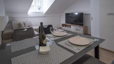 a living room with a table with two wine glasses at Vanja's Apartman in Belgrade