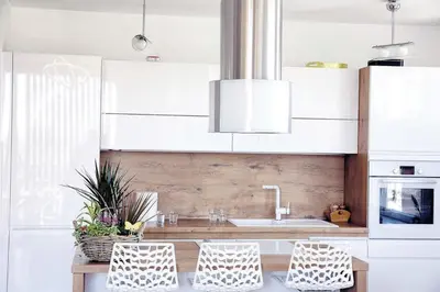 a kitchen with white cabinets and a sink and two chairs at 3BD Luxury Apartment in New Belgrade whit parking in Novi Beograd