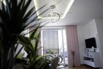 a living room with a large window and a chandelier at 3BD Luxury Apartment in New Belgrade whit parking in Novi Beograd