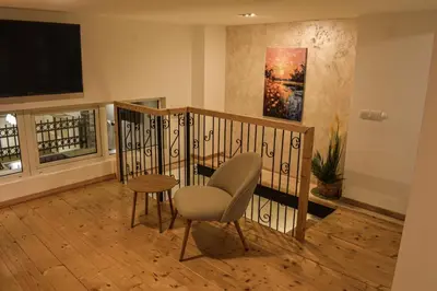a living room with a chair and a television at Urban Duplex in Belgrade