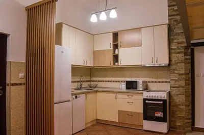 a kitchen with white cabinets and a stove top oven at Urban Duplex in Belgrade
