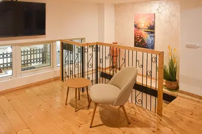 a living room with a staircase with a chair and a table at Urban Duplex in Belgrade