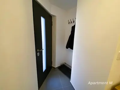 a hallway with a black door and a window at Apartman M in Belgrade