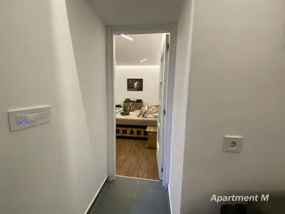 a hallway leading to a bathroom with a sink at Apartman M in Belgrade