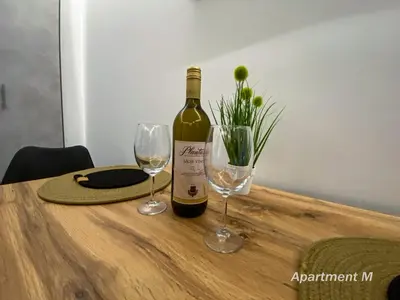 a bottle of wine and two glasses on a table at Apartman M in Belgrade