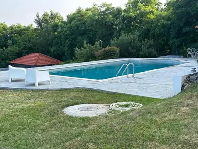 a swimming pool in a yard with a hose at Hacienda Koviona in Parcani