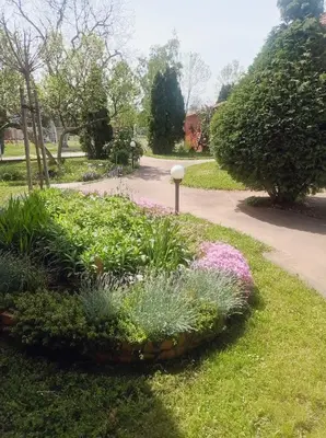 a garden with flowers in a park at Vintage Village Serbia