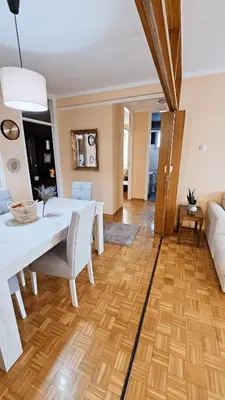 a dining room with a white table and a couch at Old Town View Apartment in Belgrade