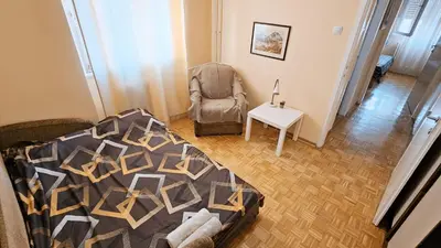 a living room with a bed and a chair at Old Town View Apartment in Belgrade