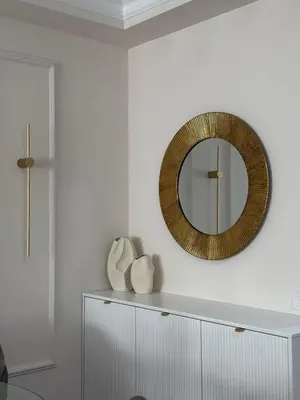 a mirror on a wall above a white cabinet at DILL apartman Arandjelovac in Arandjelovac