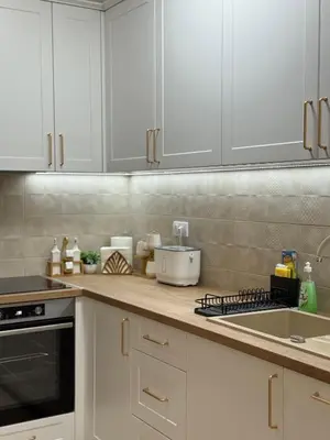 a kitchen with white cabinets and a sink at DILL apartman Arandjelovac in Arandjelovac