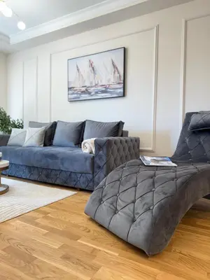 a living room with a blue couch and a table at DILL apartman Arandjelovac in Arandjelovac