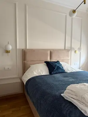 a bedroom with a bed with a blue comforter at DILL apartman Arandjelovac in Arandjelovac
