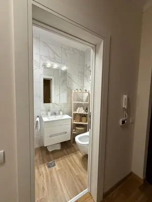 a bathroom with a sink and a toilet and a mirror at DILL apartman Arandjelovac in Arandjelovac