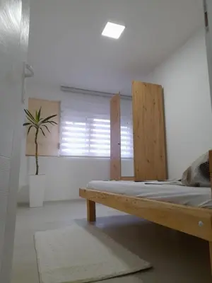 a bedroom with a wooden bed and a potted plant at Belgrade Center Lux in Belgrade