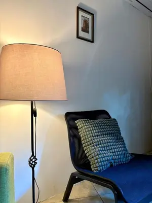 a lamp sitting next to a chair with a pillow at Tiny Home L&B in Belgrade