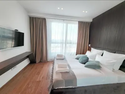 a bedroom with a large bed with a large window at Arkadija Lux Apartment River And Tower View in Belgrade