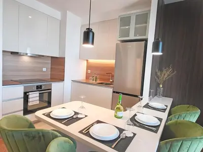a kitchen with a table with chairs and a dining room at Arkadija Lux Apartment River And Tower View in Belgrade