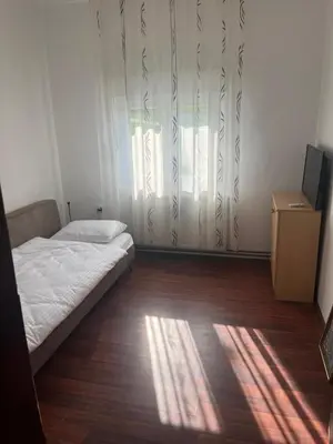 a bedroom with a bed and a window with curtains at Apartman FM in Arandjelovac