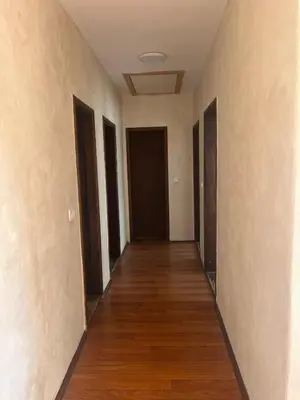 an empty hallway with doors and a wooden floor at Apartman FM in Arandjelovac