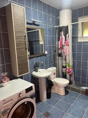 a bathroom with a washer and a toilet and a sink at Apartman FM in Arandjelovac