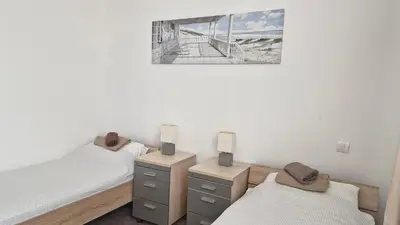 a bedroom with two twin beds and a picture on the wall at Banjica 202 in Voždovac