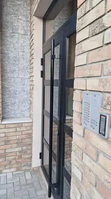 a black door on a brick building with a window at Banjica 202 in Voždovac