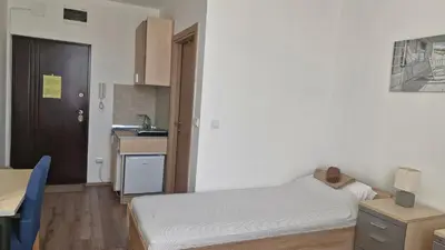 a small room with a bed and a kitchen at Banjica 202 in Voždovac