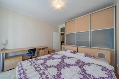 a bedroom with a large bed with a purple bedspread at In Arena Belgrade Apartment in Belgrade