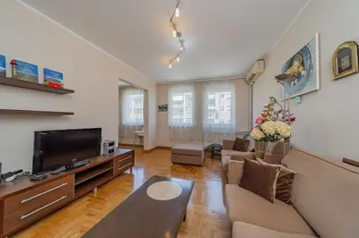 a living room with a couch and a tv at In Arena Belgrade Apartment in Belgrade