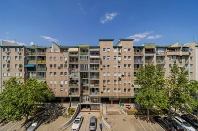 an apartment building with cars parked in a parking lot at In Arena Belgrade Apartment in Belgrade