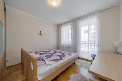a bedroom with a bed in a room with windows at In Arena Belgrade Apartment in Belgrade
