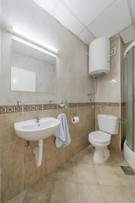 a bathroom with a sink and a toilet and a mirror at In Arena Belgrade Apartment in Belgrade