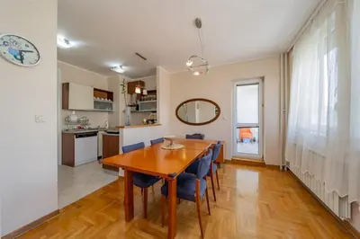 a kitchen and dining room with a wooden table and chairs at In Arena Belgrade Apartment in Belgrade