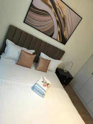 a bedroom with a white bed with a painting on the wall at Belgrade Waterfront Shine Quartet 3 in Belgrade