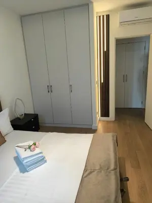 a bedroom with a bed with white cabinets and flowers on it at Belgrade Waterfront Shine Quartet 3 in Belgrade