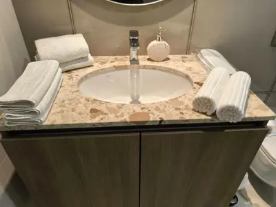 a bathroom with a sink and towels on a counter at Belgrade Waterfront Shine Quartet 3 in Belgrade
