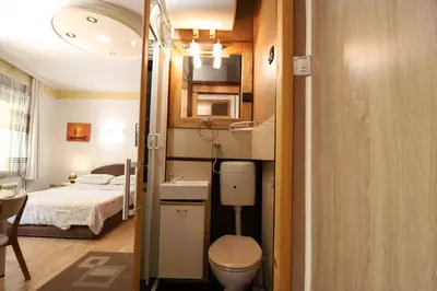 a small bathroom with a toilet and a bed at Studio Apartman Vojvoda in Belgrade