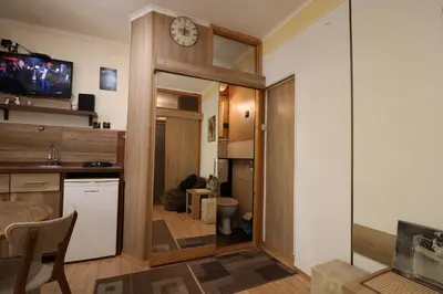 a small kitchen with a clock on the wall at Studio Apartman Vojvoda in Belgrade