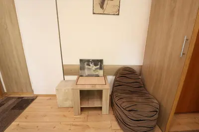 a table with a pillow next to a table with a chair at Studio Apartman Vojvoda in Belgrade