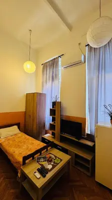 a bedroom with a bed and a table and a tv at Apartment Balkan in Belgrade