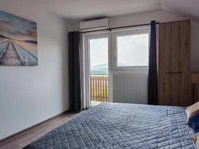 a bedroom with a bed and a large window at LipaHill Luxe in Ripanj